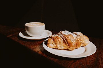 Cappuccino with latte art and croissant