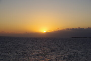 Sun peaking through clouds over the sea
