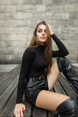 Beautiful fashion girl model with stylish elegant urban black clothes with black long sleeve shirt...