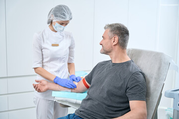 Obraz premium Smiling patient takes a blood test from a vein