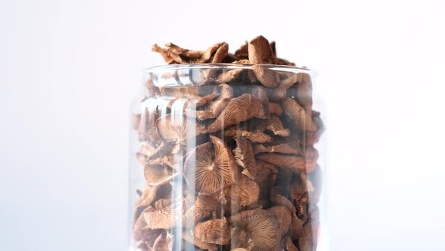 A jar of dried mushrooms rotates in a circle. Organically pure mushrooms collected in the forest. 