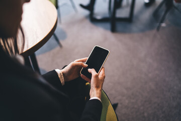 Unrecognizable businesswoman using smartphone in office