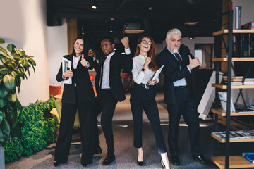 Cheerful multiracial colleagues showing thumbs up fists up gestures