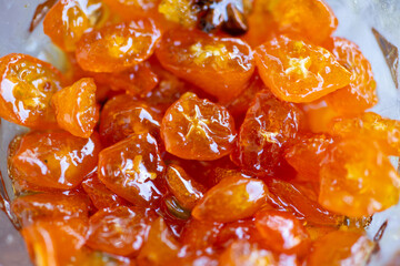 Kumquat jam: close-up, selective focus. Sweet orange background.