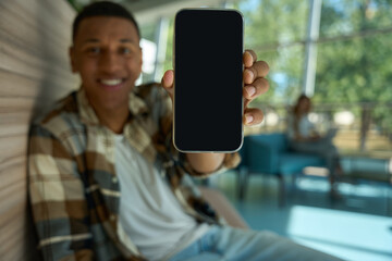 Happy young man holding his mobile phone