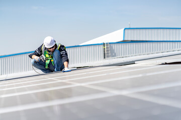 Male engineer installing or checking the working condition of solar panels on the roof or at the height of the factory for saving electricity was broken to use renewable energy from the sun