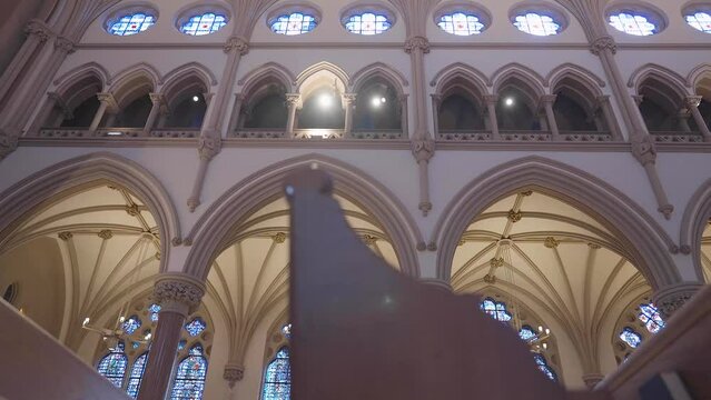 Panning through phews inside of a catholic church during a ceremony