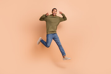 Fototapeta na wymiar Photo of crazy cheerful man running shopping black friday sale quality stylish clothes thumb up isolated on beige color background