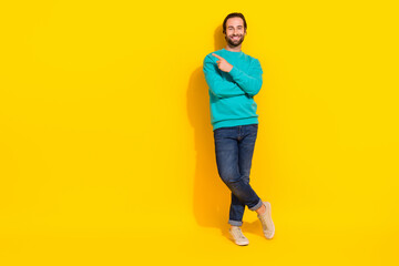 Fototapeta na wymiar Full length photo of cheerful positive guy dressed teal outfit pointing finger empty space isolated yellow color background