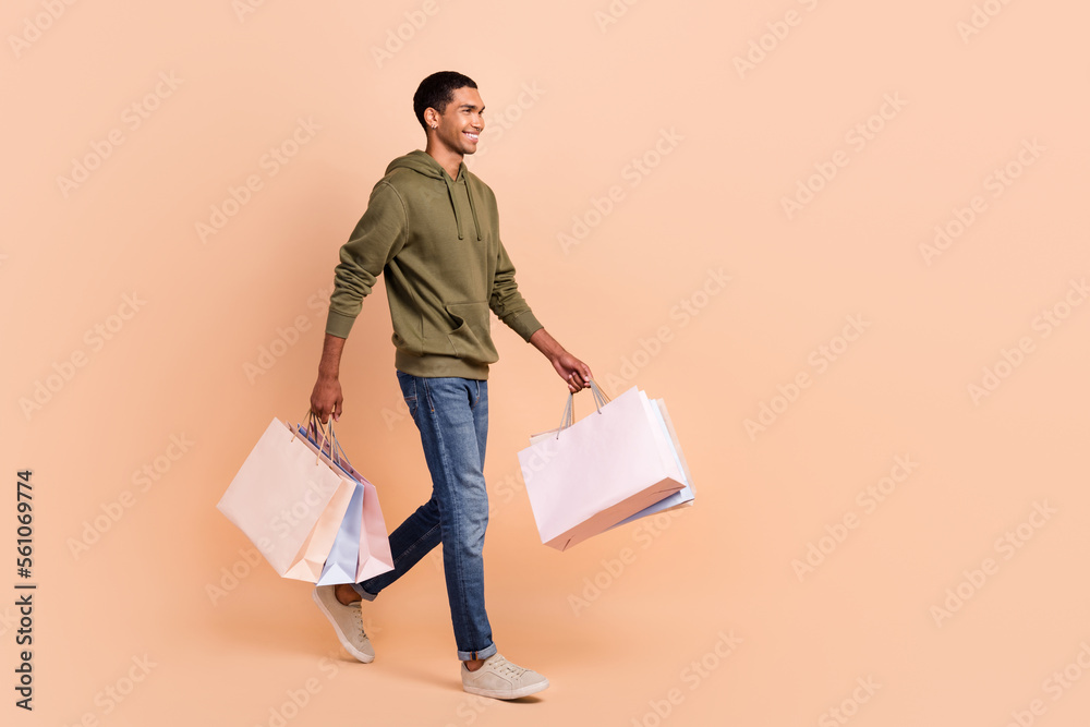 Sticker full length photo of glad nice looking man stylish clothes go mall empty space hold carry purchases 