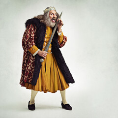 Portrait, king and man lick sword in studio isolated on gray background mockup. Victorian villain, medieval royal or mature male, evil ruler or crazy leader licking bloody blade after battle or fight