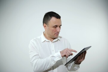 Smiling Middle Eastern Man With Digital Tablet In Hands Successful Millennial Businessman Using Tab Computer While Copy Space Pointing at tablet on white background White shirt man 40-50 years old