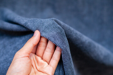 Hand holding the fabric. Women touch the fabric soft and smooth , - obrazy, fototapety, plakaty