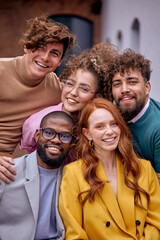Close-up Portrait of Cheerful Diverse Business People Posing At Camera Outdoors, Cheerfully Smiling, Wearing Fashionable Elegant Clothes. Friendly Caucasian And Afro American Colleagues