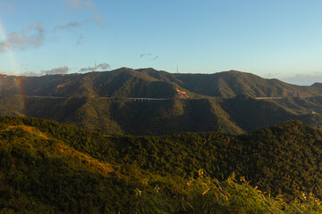 Fototapeta na wymiar Beautiful green hills road landscape on golden hour from puerto rico