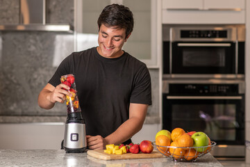hispanic teenager preparing a smoothie on a blender