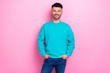 Photo of young cheerful satisfied guy wear blue jumper hands pockets successful entrepreneur...