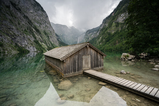H&uuml;tte mit Steg bei Regen an einem See im Nationalpark in den Bergen.