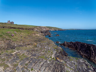 Fototapeta na wymiar Irish sea landscape. Rocky coast of the Atlantic Ocean on a sunny day. The blue sea, mountain beside body of water.