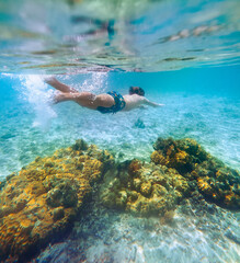 Diving teenage boy snorkeling over the coral reefs underwater photo in the clean turquoise lagoon on Le Morne beach. Mauritius island. Exotic traveling and underwater eco concept.