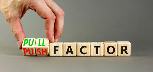 Pull or push factor symbol. Concept word Pull factor and Push factor on wooden cubes. Beautiful grey table grey background. Businessman hand. Business pull or push factor concept. Copy space.