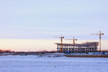 Fototapeta na wymiar Winter view of the construction of the terminal of the international cable car between Russia and China on the banks of the Amur River. State border on a frosty morning. Barbed wire fences on ice.