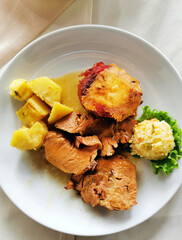 Stewed pork with boiled potatoes and garnish.
