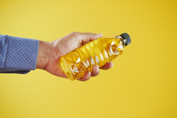 men holding a yellow sunflower oil bottle