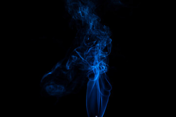 Fototapeta premium incense stick with blue smoke against black background