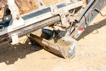 Concrete mixer truck pouring fresh wet concrete into excavators bucket at a construction site