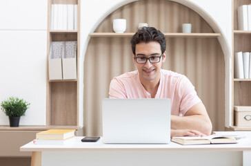 Fototapeta premium Young handsome man studying online at home. Distance education concept 