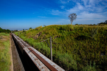 Freight train with numerous wagons between hills on Minas Geraes, Brazil