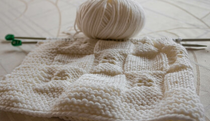 Fototapeta na wymiar White knitting wool texture closeup, a ball of white wool background