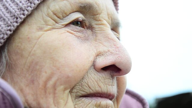 The face of an old grandmother. Wrinkled face close-up. Ukrainian woman during the war. Ukrainian refugees. Destructive war in Ukraine. Peace concept. An old woman during the war. Russian aggression
