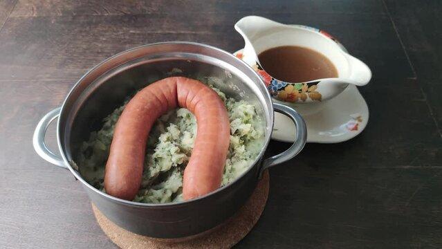 Traditional dutch dish Boerenkool Stamppot, consisting of potatoes mashed with kale, smoked sausage and gravy