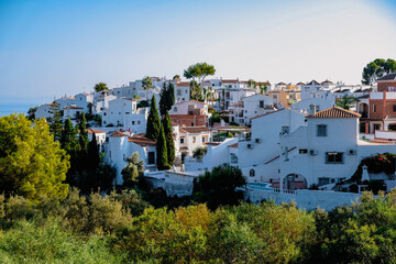 Fototapeta na wymiar Spanish village on a hill with many white buildigs in Nerja, Spain