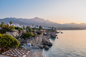 Iconic sunrise view of El Chorrillo beach in Nerja, Balcon de Europa, golden morning light, travel destinations © Lucky Ev