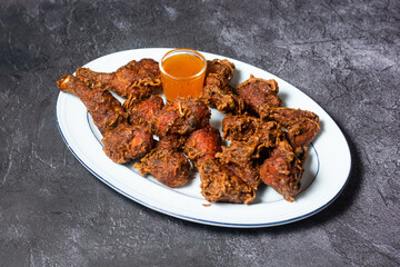 Spicy Fried Chicken with sauce served in dish isolated on grey background top view of indian and bangladesh food