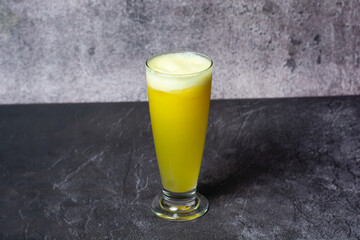Fresh Pineapple Juice served in glass isolated on grey background top view of indian and bangladesh food