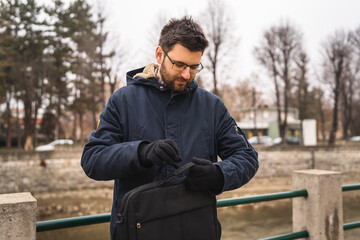 Fototapeta na wymiar One bearded caucasian man with laptop bag standing outdoor in winter