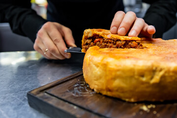 chef hand preparing a gourmet meat pie on restaurant kitchen