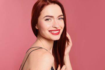 Fototapeta premium Happy woman with red dyed hair on pink background