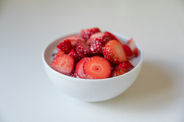 Bowl of strawberry with milkshake in a table of the kitchen