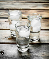 Vodka in a shot glass and ice cubes.