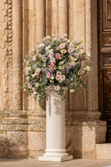 Luxury wedding floral decorations at the entrance of Ostuni church. Wedding celebrations in south...
