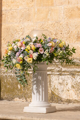 Fototapeta na wymiar Luxury wedding floral decorations at the entrance of Ostuni church. Wedding celebrations in south Italy. Big bouquets of colorful flowers.