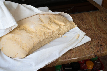 Casadielles dough after rising, protected by a table cloth.