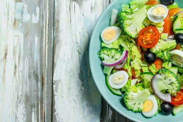 Vegetable salad. Salad of tomatoes, cucumbers and quail eggs with olive oil.