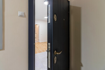 An open home metal door, black. Entrance to the apartment