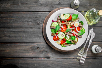Healthy salad. Salad with boiled beef, vegetables and quail eggs.